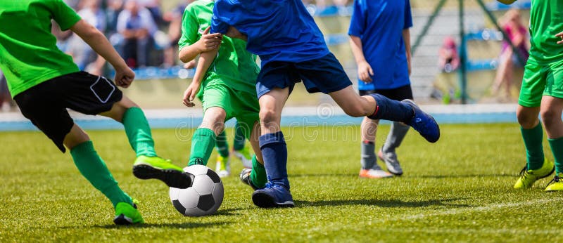 Jogadores de futebol novos running do futebol Jogadores de futebol que retrocedem o jogo de fósforo do futebol fotos de stock royalty free Jogadores de futebol novos running do futebol Jogadores de futebol que retrocedem o jogo de fósforo do futebol fotos de stock royalty free