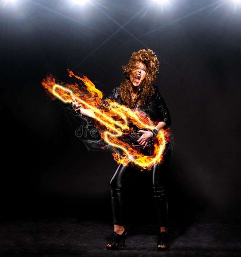 Woman is playing rock music on fiery guitar. Woman is playing rock music on fiery guitar