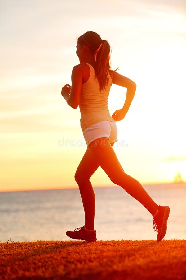 Jogga idrottsman nenkvinnaspring på solsolnedgången sätta på land
