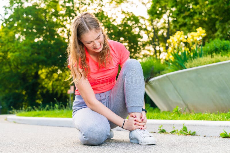 A Jogger Has Injured Her Ankle during Sports and Holds it Tight Stock ...