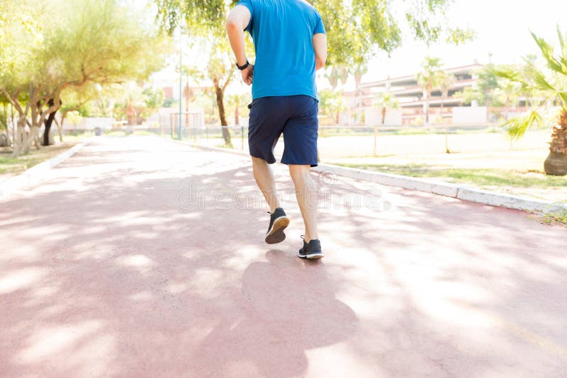 Jogger Opleiding op Voetpad tijdens Sunny Day In Park stock afbeeldingen Jogger Opleiding op Voetpad tijdens Sunny Day In Park stock afbeeldingen