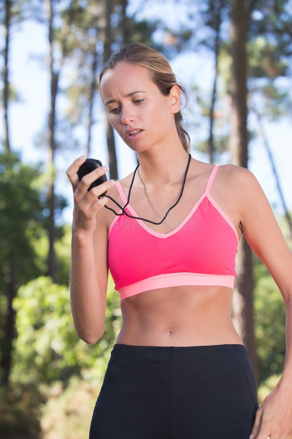 Jogger молодой женщины, проверяя на секундомере стоковая фотография rf
