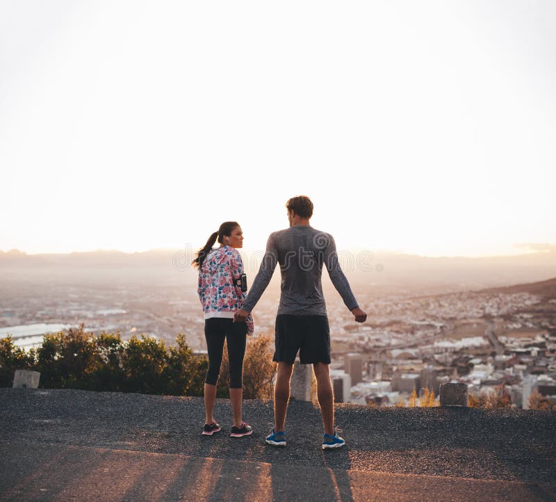 Rear view of lesbian couple standing of roof terrace looking