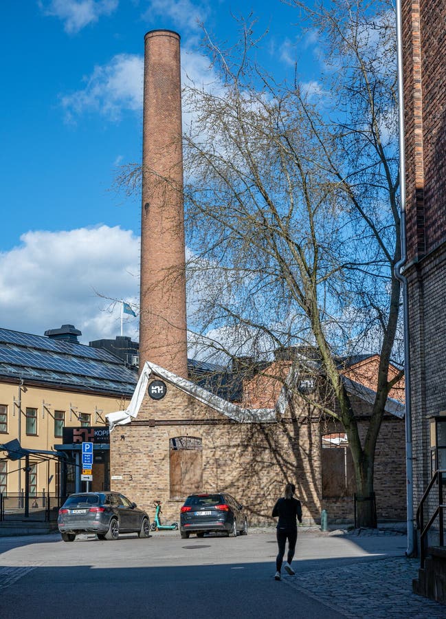 Norrkping, Sweden - May 2, 2023: Woman jogging in the old industrial landscape during spring. Norrkoping is a historic industrial town in Sweden. Norrkping, Sweden - May 2, 2023: Woman jogging in the old industrial landscape during spring. Norrkoping is a historic industrial town in Sweden.