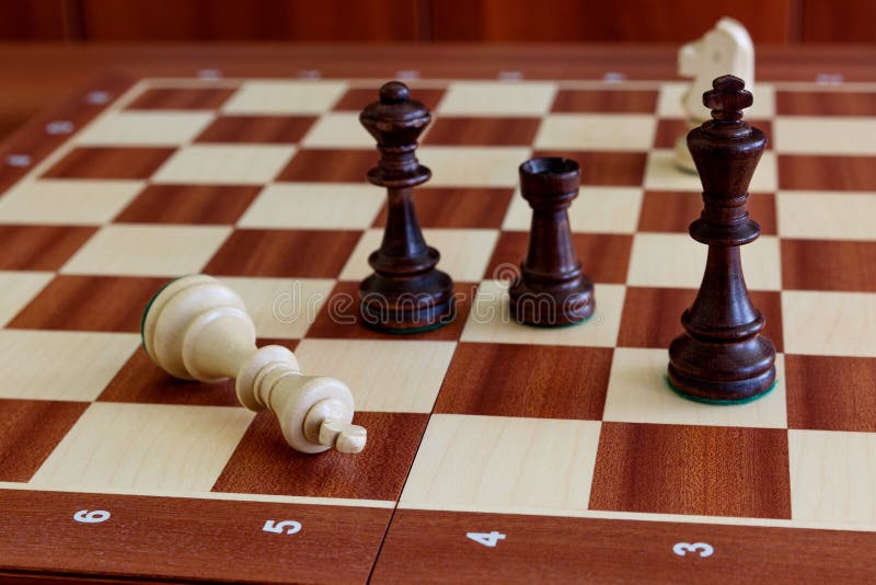 Peças de xadrez com rei na posição de liderança, colocadas na mesa de  escritório