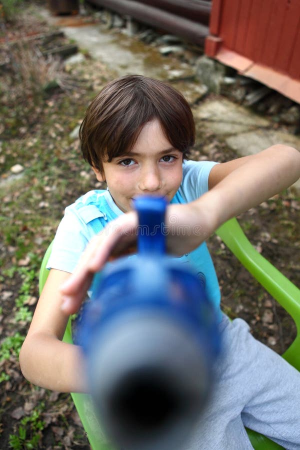 Jogo considerável do menino do Preteen com arma de água imagens de stock royalty free Jogo considerável do menino do Preteen com arma de água imagens de stock royalty free
