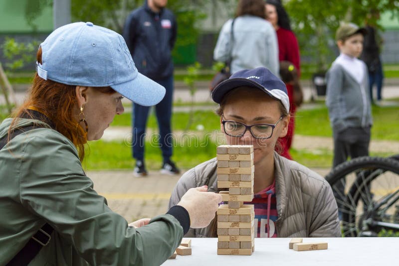 Jogo JENGA da mulher e da menina fora da tabela fotografia de stock royalty free Jogo JENGA da mulher e da menina fora da tabela fotografia de stock royalty free