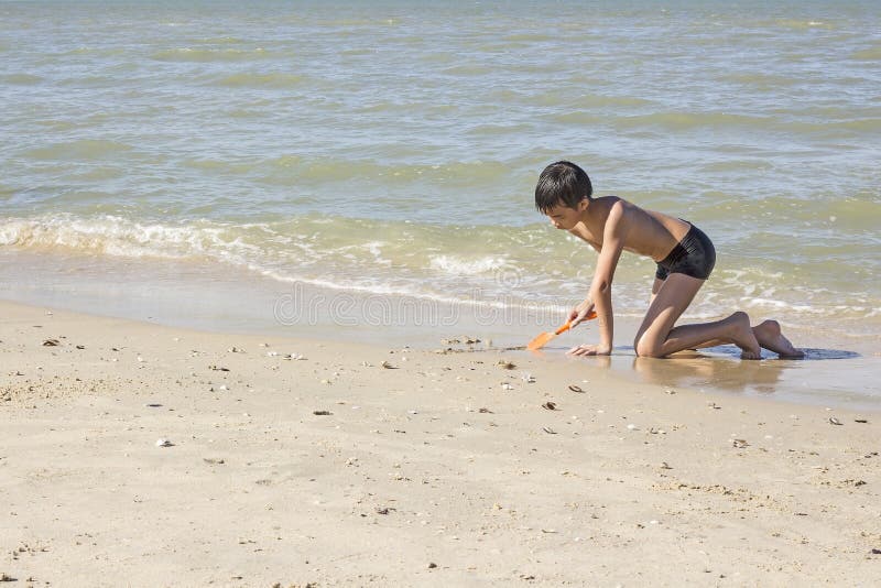 Jogos Dos Meninos Na Praia Com Areia Foto de Stock - Imagem de