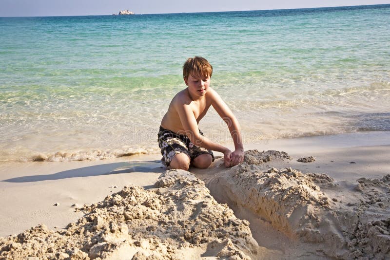 Jogos Dos Meninos Na Praia Com Areia Foto de Stock - Imagem de