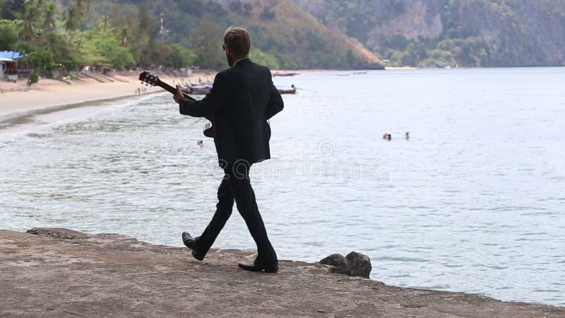 Jogos e caminhadas do guitarrista contra a praia