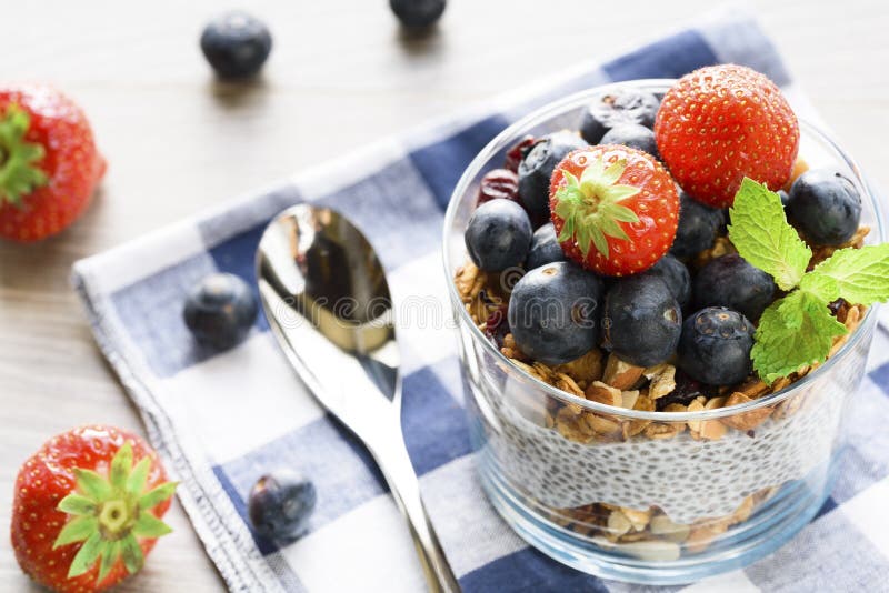 Jogurt mit Granola, frischen Blaubeeren, chia Samen und Hafern in einem Glas über hölzernem Hintergrund Abschluss oben lizenzfreies stockfoto Jogurt mit Granola, frischen Blaubeeren, chia Samen und Hafern in einem Glas über hölzernem Hintergrund Abschluss oben lizenzfreies stockfoto