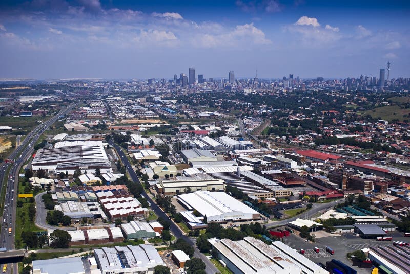 Aerial view of the eastern industrial suburbs adjacent to the CBD. The financial capital of South Africa, Johannesburg is found in the province of Gauteng. In the background is the CBD, with all it's high-rise skyscrapers. Aerial view of the eastern industrial suburbs adjacent to the CBD. The financial capital of South Africa, Johannesburg is found in the province of Gauteng. In the background is the CBD, with all it's high-rise skyscrapers.