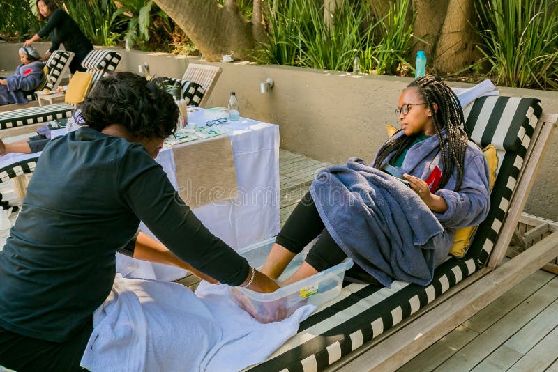 Diverse women in bath robes receiving a pedicure at spa resort stock photos Diverse women in bath robes receiving a pedicure at spa resort stock photos