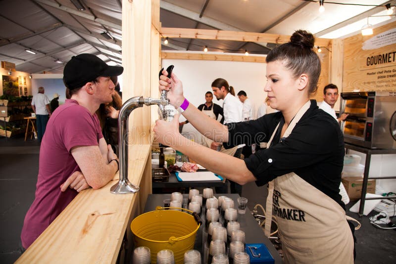 Female Bartender pouring a draught beer at a food festival stock image Female Bartender pouring a draught beer at a food festival stock image