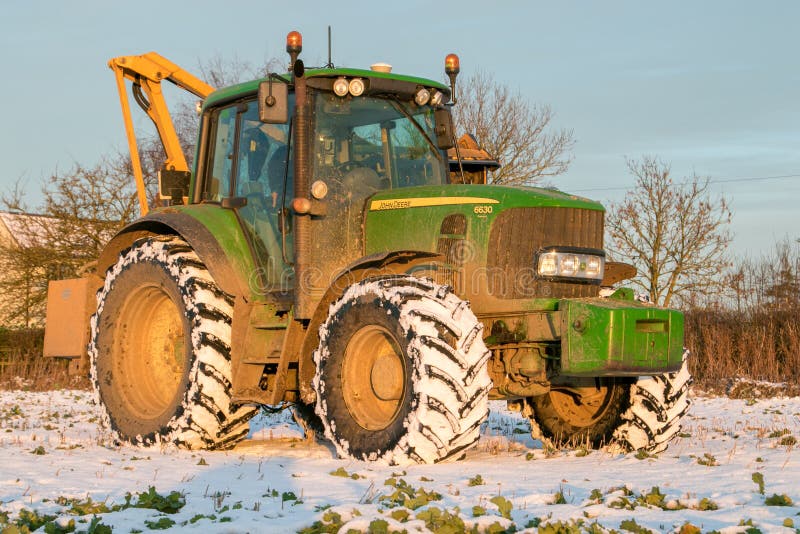 John Deere Tractor Cutting Hedges in Snow Editorial Photography Image