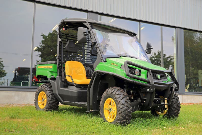 SALO, FINLAND - AUGUST 9, 2014: John Deere Gator XUV550 Crossover Utility Vehicle on grass. The Gator has a V-twin engine and independent four-wheel suspension. SALO, FINLAND - AUGUST 9, 2014: John Deere Gator XUV550 Crossover Utility Vehicle on grass. The Gator has a V-twin engine and independent four-wheel suspension.