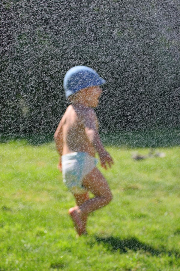 Silhouette of baby enjoying a water spray. Silhouette of baby enjoying a water spray