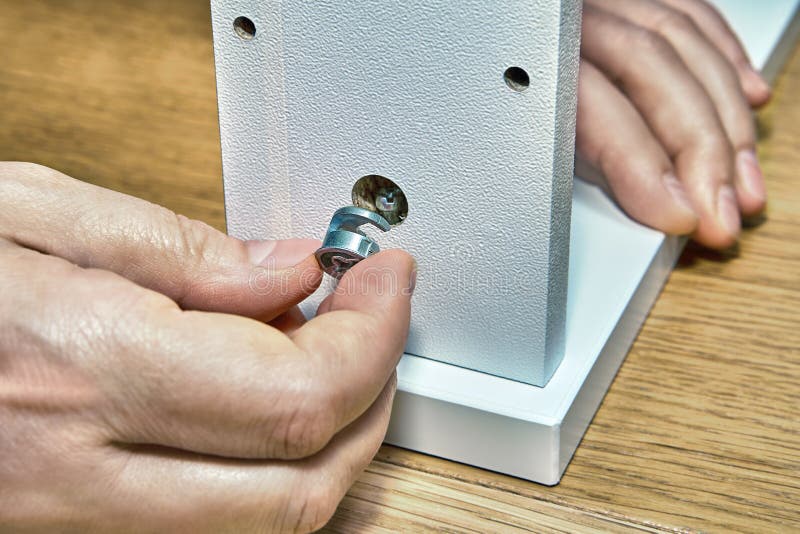 Joiner is inserted one nut he uses furniture connecting fittings royalty free stock photo Joiner is inserted one nut he uses furniture connecting fittings royalty free stock photo