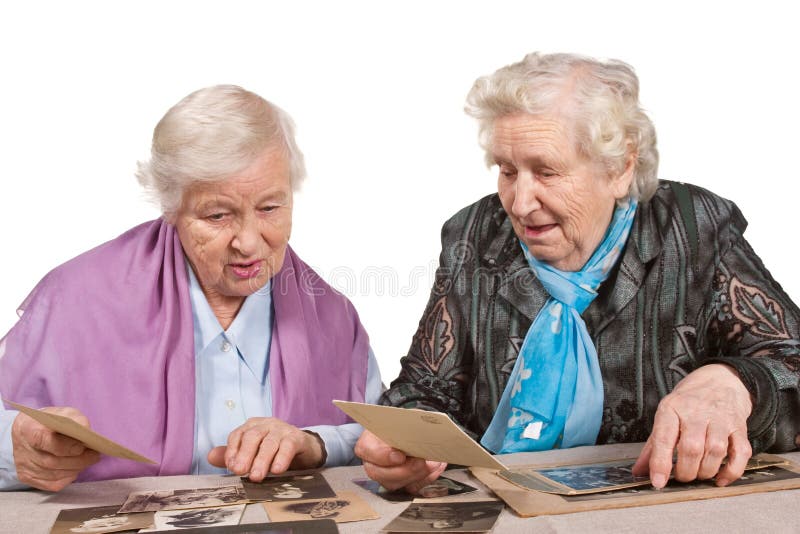 Dve staré ženy spolu pohľade na historických fotografiách.