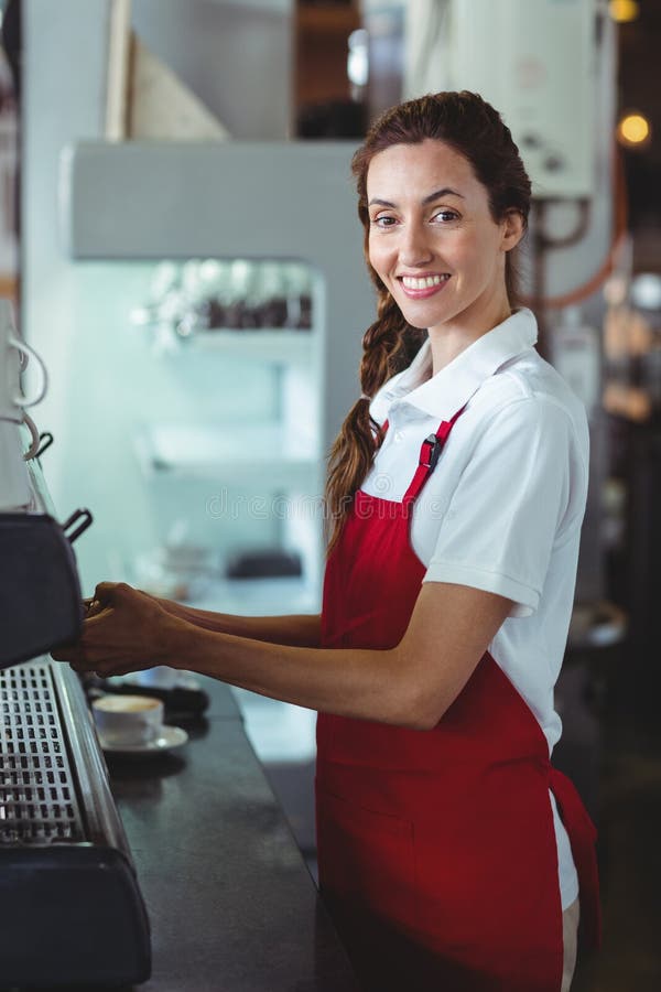 Download Joli Barman Regardant L'appareil-photo Et à L'aide De La Machine De Café Image stock - Image du brunette, industrie: 56486839