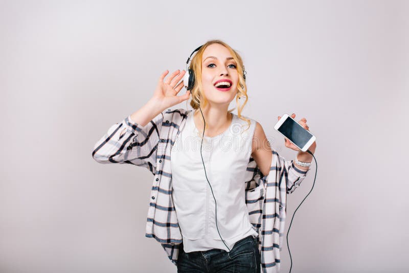 Joli portrait gentil de femme magnifique avec plaisir avec les cheveux blonds Danse heureuse de fille de musique contre le gris d photographie stock libre de droits Joli portrait gentil de femme magnifique avec plaisir avec les cheveux blonds Danse heureuse de fille de musique contre le gris d photographie stock libre de droits