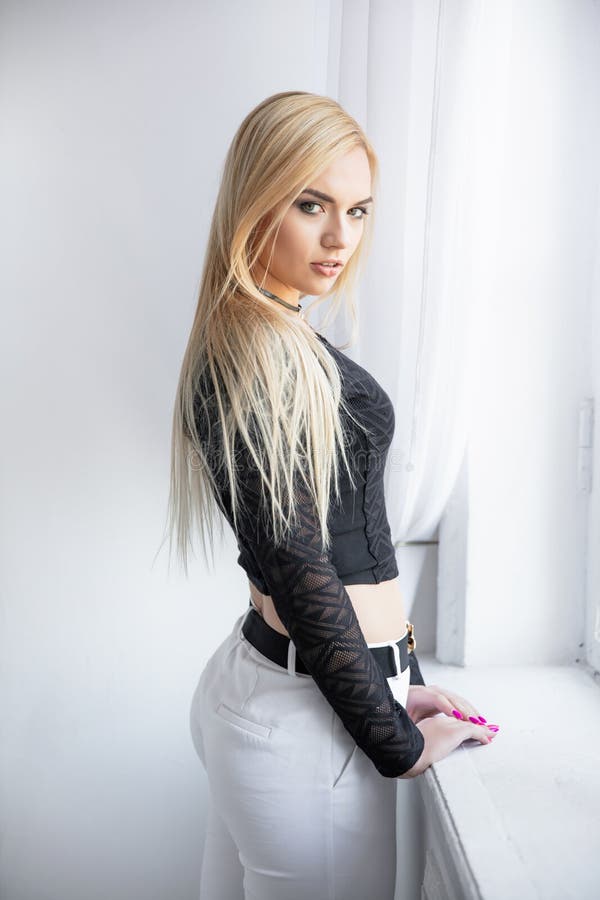 Photo libre de droit de Jolie Jeune Femme Blonde Avec Des Pantalons Serrés  banque d'images et plus d'images libres de droit de A la mode - A la mode,  Adulte, Beauté 