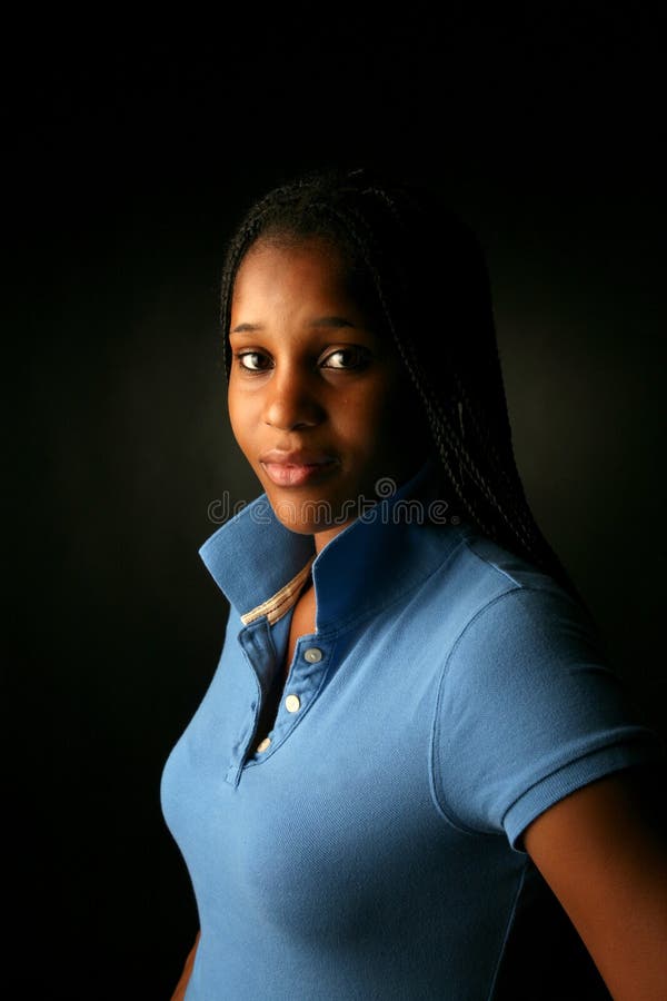 Pretty black teenage girl with the collar of her blue shirt turned up. Pretty black teenage girl with the collar of her blue shirt turned up