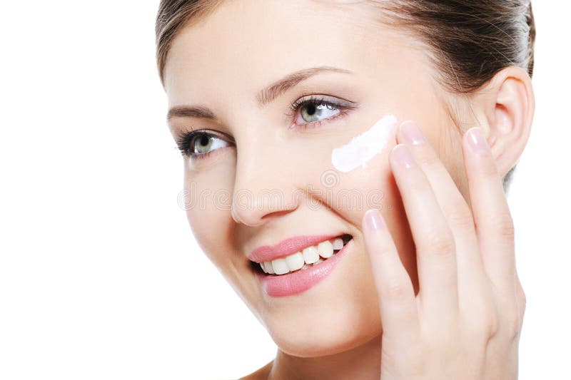 Jolie crème cosmétique de application femelle sur le visage images libres de droits