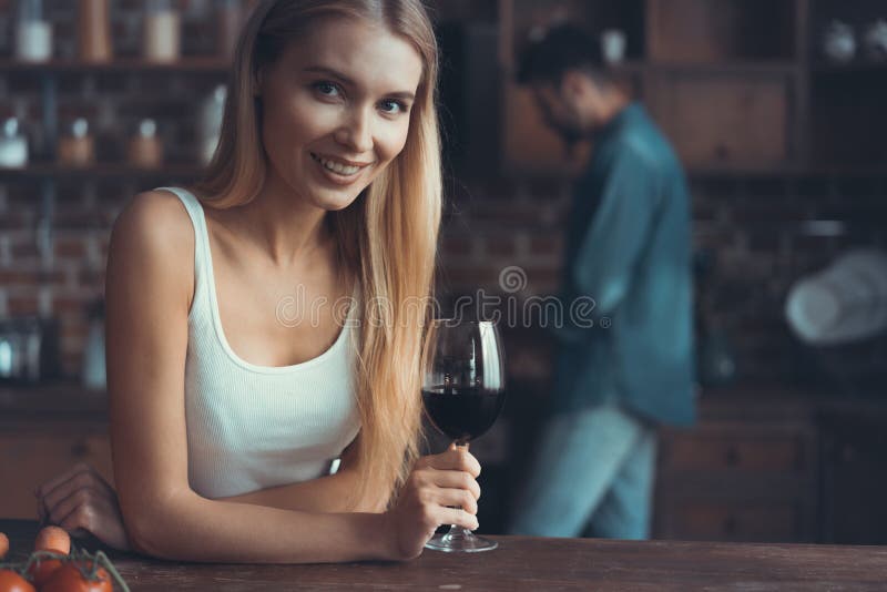 Jolie femme buvant du vin à la maison dans la cuisine photos stock