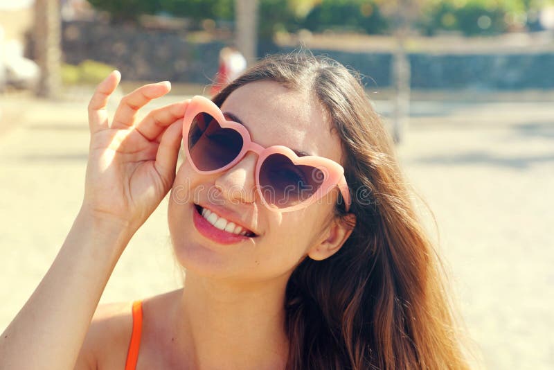 Jolie femme de brune dans des lunettes de soleil roses de lolita de coeur sur la plage Vacances, voyage de vacances et concept de images stock Jolie femme de brune dans des lunettes de soleil roses de lolita de coeur sur la plage Vacances, voyage de vacances et concept de images stock