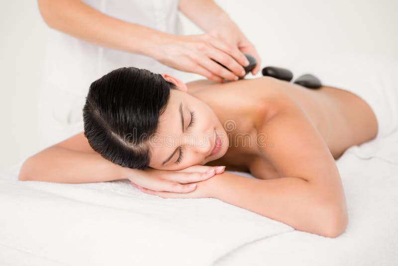 Jolie femme recevant un massage en pierre chaud image stock Jolie femme recevant un massage en pierre chaud image stock