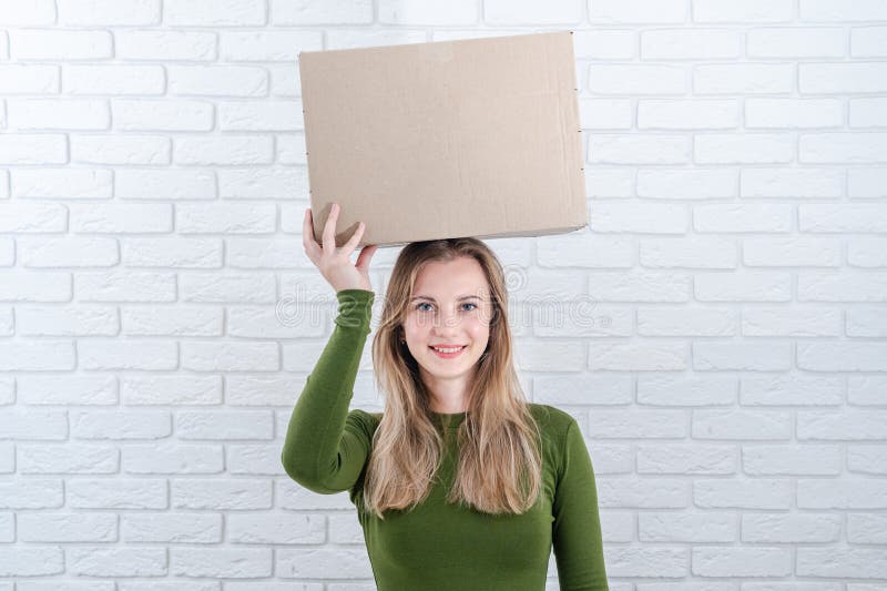 Jolie femme tenant boîte de colis sur la tête. livraison d'un colis photographie stock