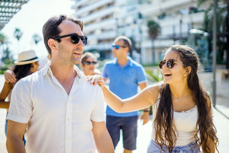Jolie fille et garçon beau traînant avec des amis pendant le soleil image libre de droits Jolie fille et garçon beau traînant avec des amis pendant le soleil image libre de droits