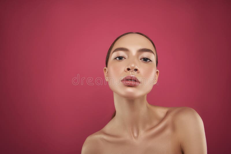 Jolie fille sûre avec le maquillage naturel se tenant sur le fond rose photos libres de droits Jolie fille sûre avec le maquillage naturel se tenant sur le fond rose photos libres de droits
