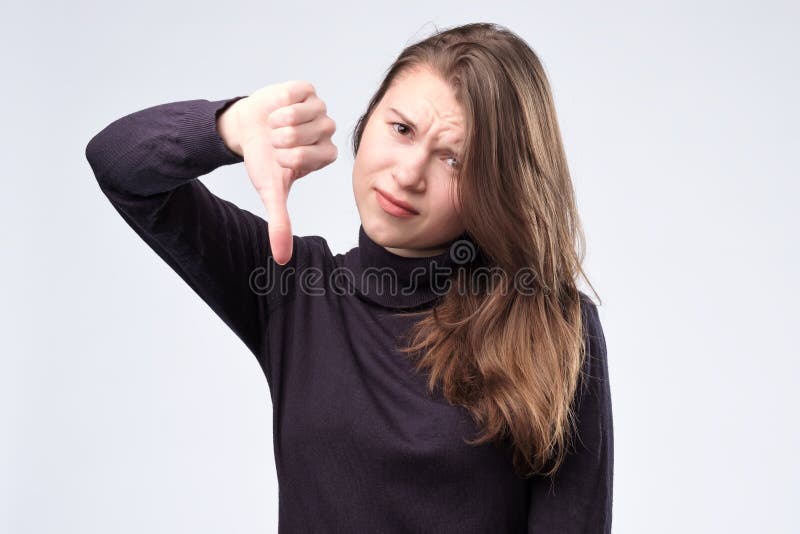 Jolie jeune femme maniant maladroitement vers le bas, d'isolement sur le fond blanc photo libre de droits Jolie jeune femme maniant maladroitement vers le bas, d'isolement sur le fond blanc photo libre de droits