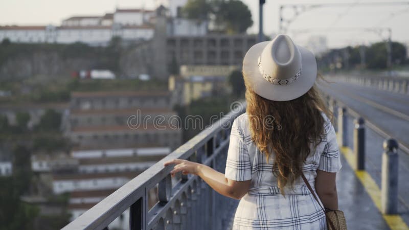 Jolies femmes dans le chapeau marchant sur le pont