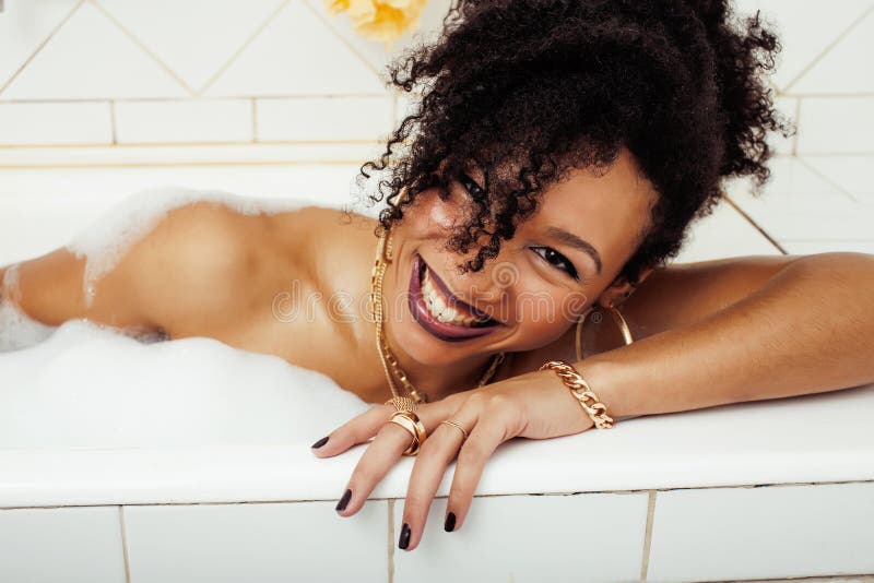 Jong Afro-Amerikaans tienermeisje die in bad met schuim leggen, die swag onberispelijke juwelen dragen, makend selfie stock afbeeldingen Jong Afro-Amerikaans tienermeisje die in bad met schuim leggen, die swag onberispelijke juwelen dragen, makend selfie stock afbeeldingen