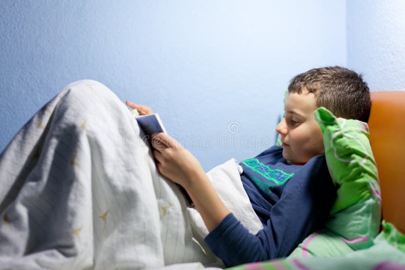 Jong geitje dat een boek leest bij bedtijd