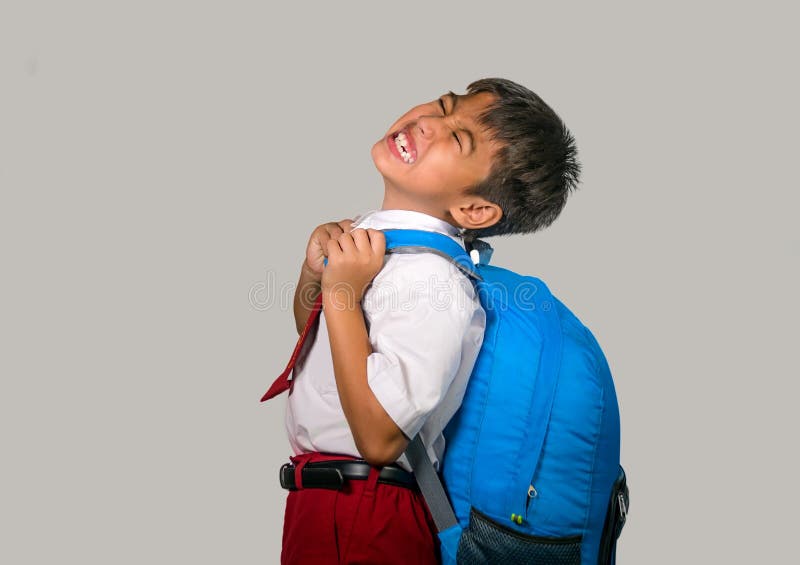 Jong geitje in eenvormig het dragen verstoord zakhoogtepunt van boeken die en over het gewicht van de rugzak in luie schooljongen royalty-vrije stock fotografie Jong geitje in eenvormig het dragen verstoord zakhoogtepunt van boeken die en over het gewicht van de rugzak in luie schooljongen royalty-vrije stock fotografie