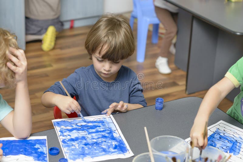 Jong geitje het Schilderen bij Kleuterschool royalty-vrije stock afbeeldingen Jong geitje het Schilderen bij Kleuterschool royalty-vrije stock afbeeldingen
