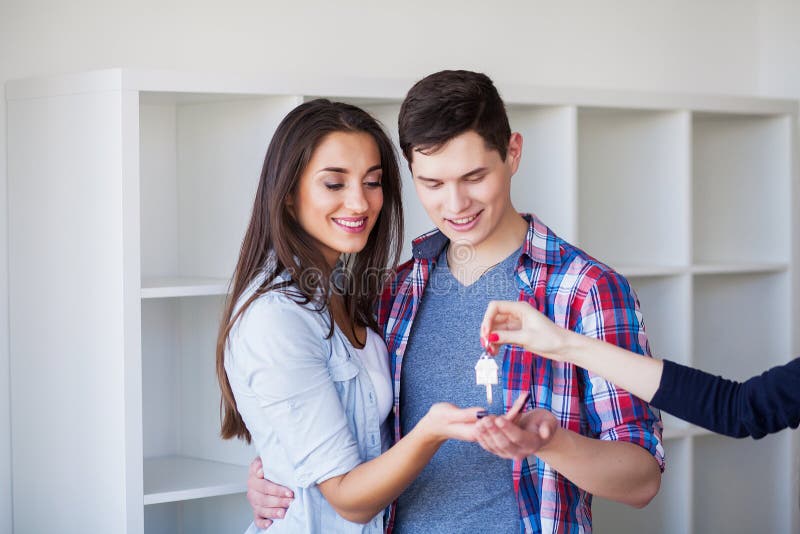 Jong gelukkig paar dat zich in hun nieuw huis beweegt Zij die en nieuw huis uitpakken schoonmaken stock afbeelding Jong gelukkig paar dat zich in hun nieuw huis beweegt Zij die en nieuw huis uitpakken schoonmaken stock afbeelding