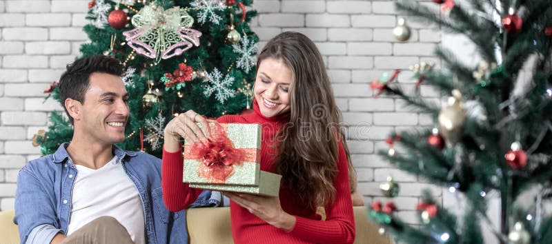 Jong knap Causacian-paar, doos van de vrouwen de open gift, het zitten stock afbeelding Jong knap Causacian-paar, doos van de vrouwen de open gift, het zitten stock afbeelding