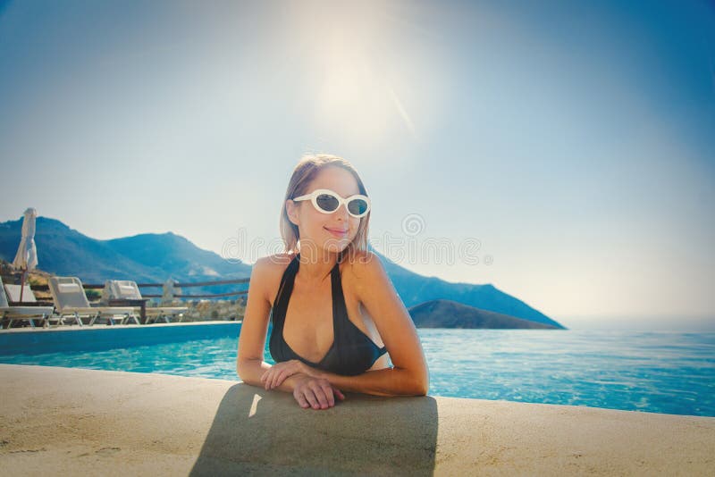 Jong meisje in bikini en zonnebril in een pool stock fotografie Jong meisje in bikini en zonnebril in een pool stock fotografie