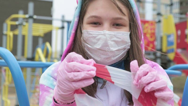 Jong meisje in een beschermmasker op speelplaats.