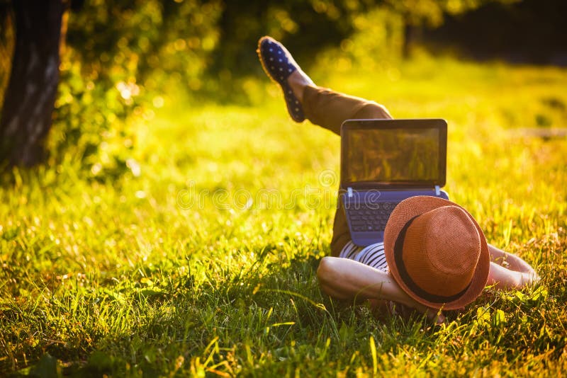 Jong meisje in het park die met laptop werken stock fotografie Jong meisje in het park die met laptop werken stock fotografie