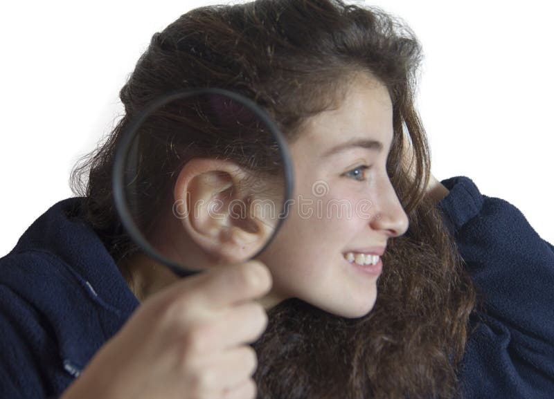 Jong meisje met een vergrootglas naast haar oor stock foto Jong meisje met een vergrootglas naast haar oor stock foto