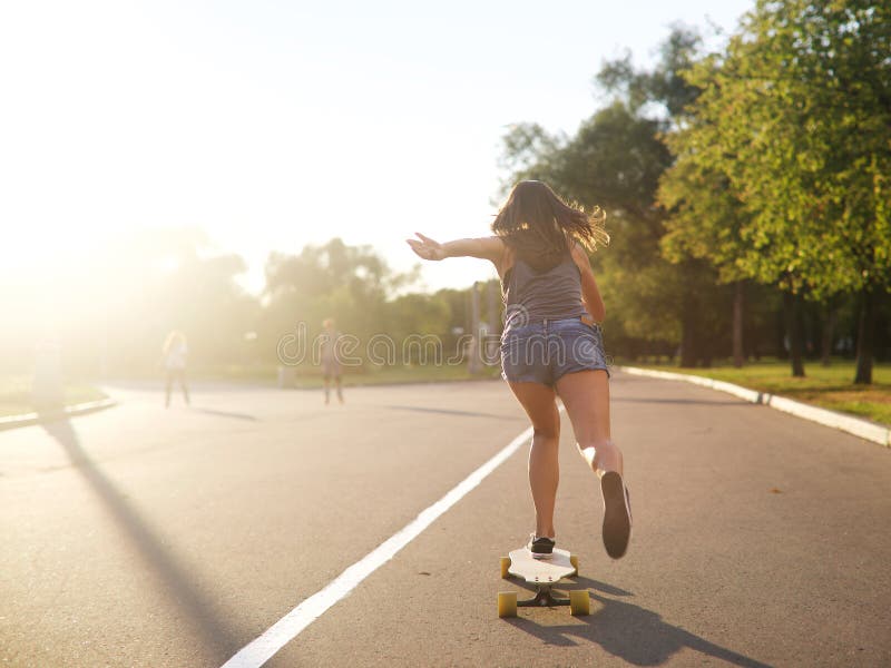 Jong meisje op longboard stock afbeelding. Image of vrijetijdsbesteding