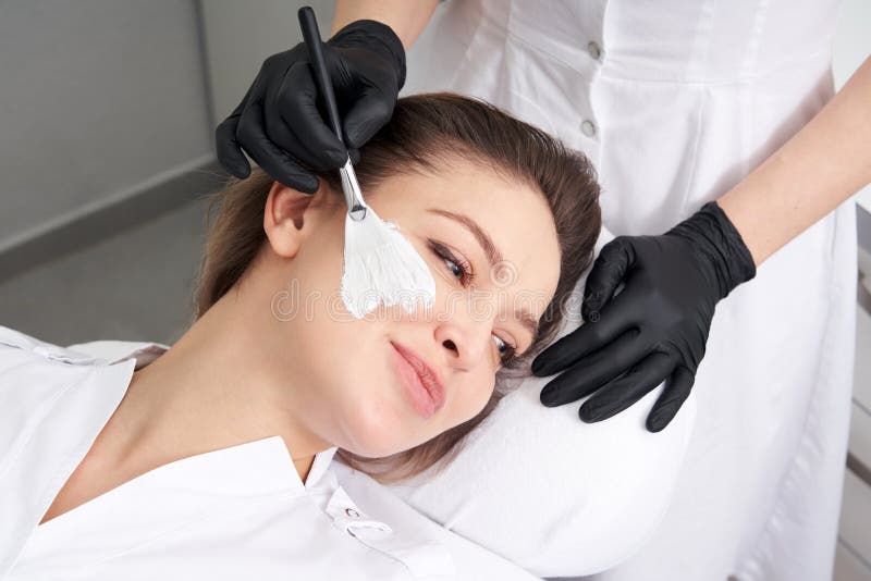 Young beautiful girl receiving facial mask in spa beauty salon - indoors. Young beautiful girl receiving facial mask in spa beauty salon - indoors