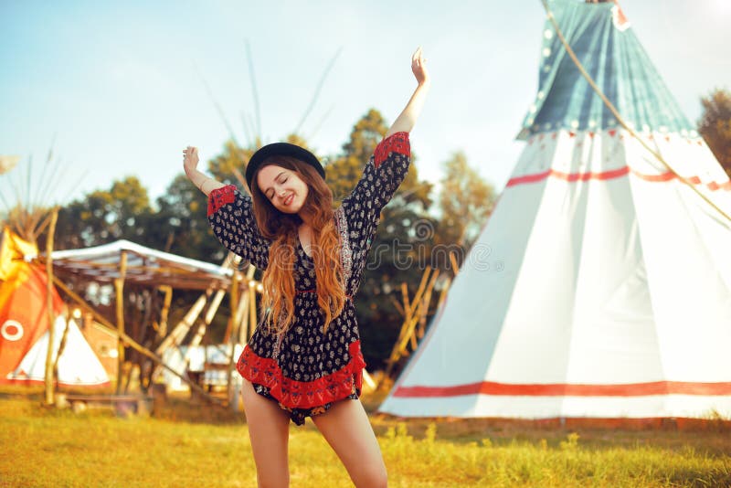 Jong mooi meisje die op achtergrondtipi, tipi inheems Indisch huis glimlachen Mooi meisje in hoed met lang cerly haar royalty-vrije stock foto's Jong mooi meisje die op achtergrondtipi, tipi inheems Indisch huis glimlachen Mooi meisje in hoed met lang cerly haar royalty-vrije stock foto's