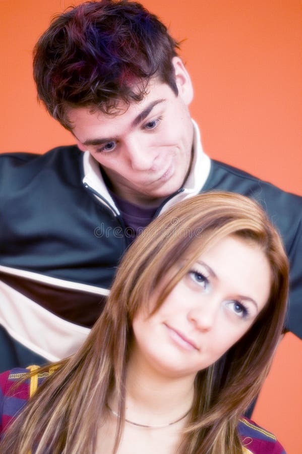 Young couple with silly expressions, orange background. Young couple with silly expressions, orange background